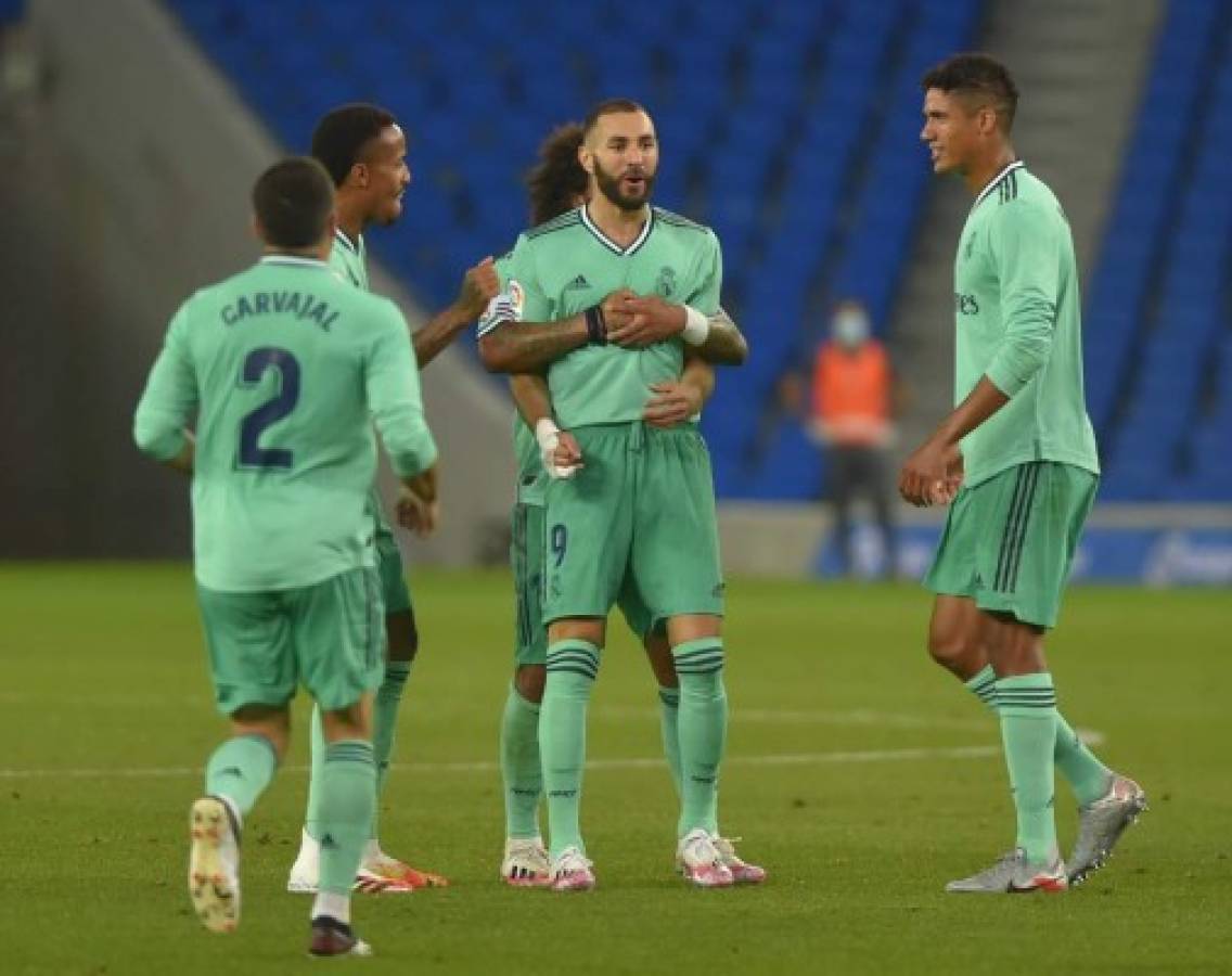 Real Madrid's French forward Karim Benzema (R) celebrates with teammates after scoring during the Spanish League football match between Real Sociedad and Real Madrid at the Reale Arena-Anoeta Stadium in San Sebastian on June 21, 2020. (Photo by ANDER GILLENEA / AFP)