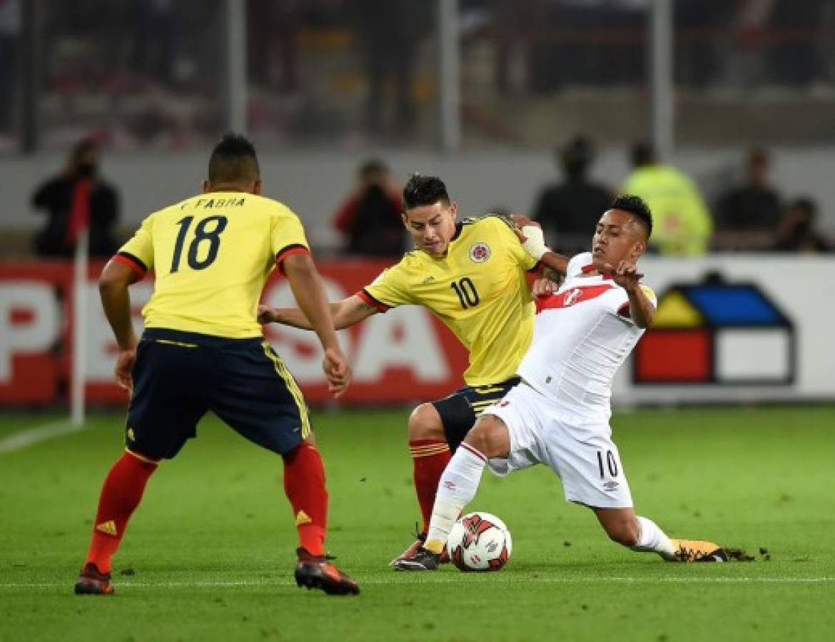 Colombia's James Rodriguez (C) and Peru's Christian Cueva (R) vie for the ball during their 2018 World Cup qualifier football match in Lima, on October 10, 2017. / AFP PHOTO / CRIS BOURONCLE