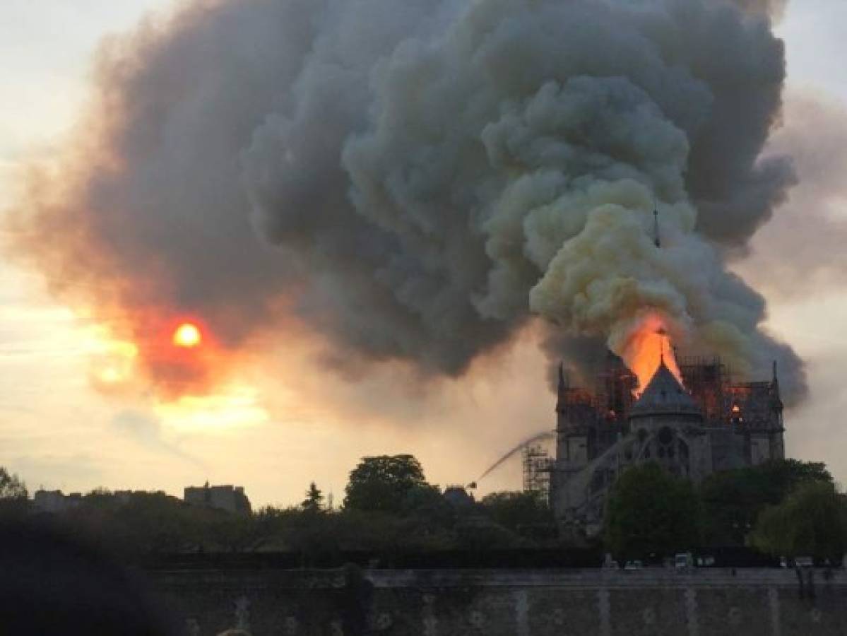 Flames and smoke are seen billowing from the roof at Notre-Dame Cathedral in Paris on April 15, 2019. - A fire broke out at the landmark Notre-Dame Cathedral in central Paris, potentially involving renovation works being carried out at the site, the fire service said.Images posted on social media showed flames and huge clouds of smoke billowing above the roof of the gothic cathedral, the most visited historic monument in Europe. (Photo by Fouad Maghrane / AFP)