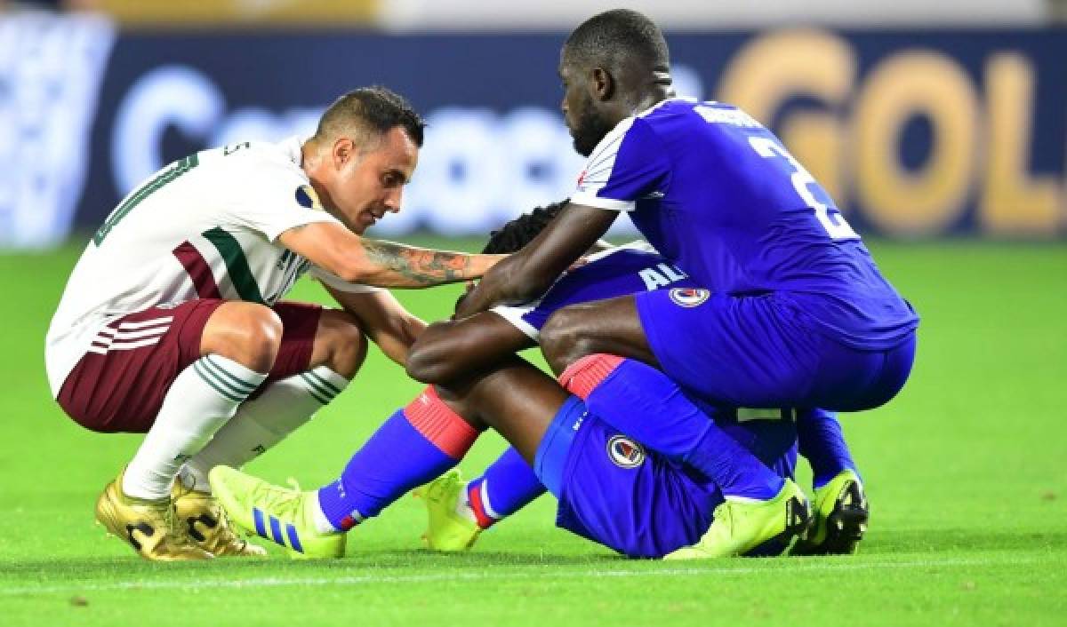 Mexico's Luis Montes (L) consoles Haiti's Bryan Alceus (C) and Carlens Arcus following Mexico's 1-0 extra time win over Haiti during their 2019 Concacaf Gold Cup semifinal football match on July 2, 2019 in Glendale, Arizona. (Photo by Frederic J. BROWN / AFP)