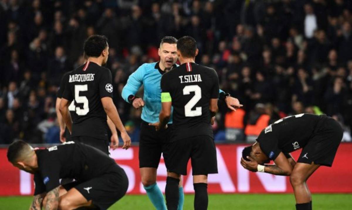 Slovenia's referee Damir Skomina (C) shows after videoassist the penalty spot during the UEFA Champions League round of 16 second-leg football match between Paris Saint-Germain (PSG) and Manchester United at the Parc des Princes stadium in Paris on March 6, 2019. (Photo by Anne-Christine POUJOULAT / AFP)