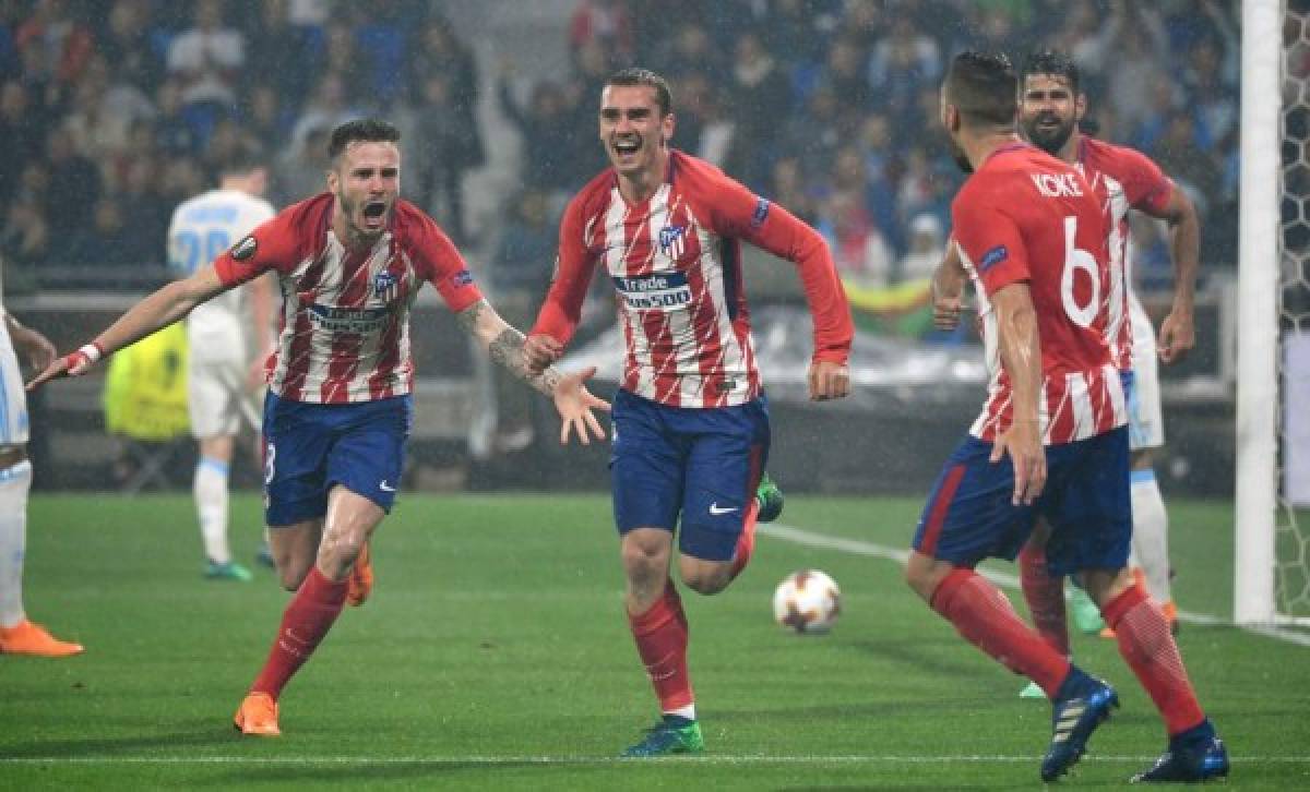 Atletico Madrid's French forward Antoine Griezmann (C) celebrates past Atletico Madrid's Spanish midfielder Saul Niguez(L) after scoring his second goal during the UEFA Europa League final football match between Olympique de Marseille and Club Atletico de Madrid at the Parc OL stadium in Decines-Charpieu, near Lyon on May 16, 2018. / AFP PHOTO / Philippe DESMAZES