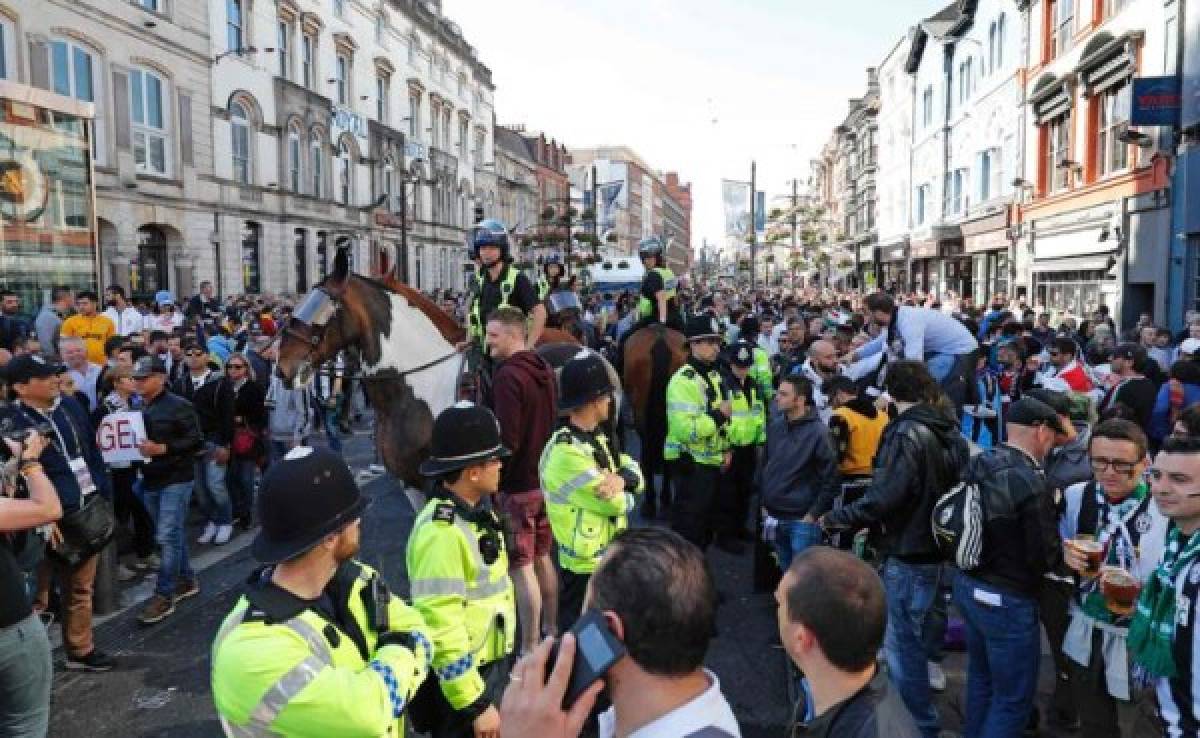 Police mix with supporters as the atmosphere builds in the streets before the UEFA Champions League final football match between Juventus and Real Madrid in Cardiff, south Wales, on June 3, 2017. / AFP PHOTO / Adrian DENNIS