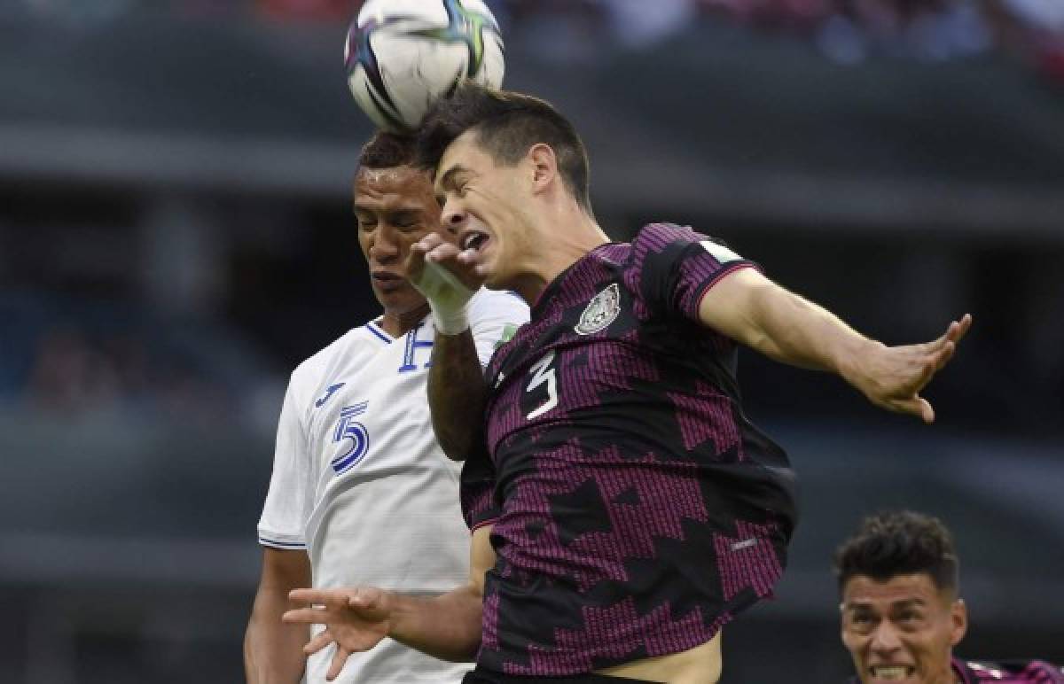 Honduras's Kervin Arriaga (L) and Mexico's Hector Moreno (R) vie for the ball during their Qatar 2022 FIFA World Cup Concacaf qualifier match at the Azteca stadium in Mexico City, on October 10, 2021. (Photo by ALFREDO ESTRELLA / AFP)