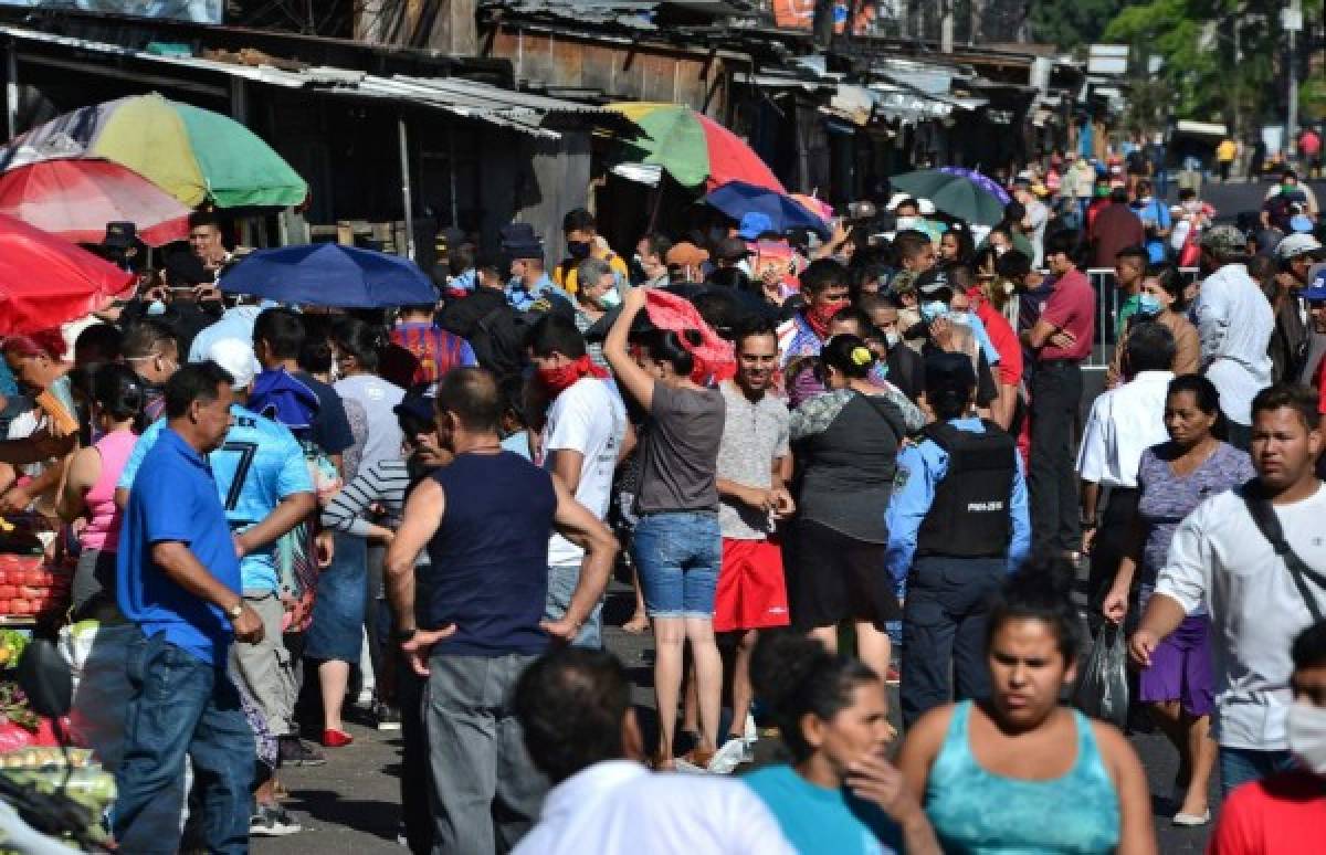 People queue at the crowded El Mayoreo market in Tegucigalpa on March 23, 2020 despite an 'absolute curfew' ordered by the Honduran government to slow the spread of the new coronavirus, COVID-19. - Days ago, the government decreed 'an absolute curfew' to force the population to isolate themselves in their homes and curb the spread of the virus in the poor Central American country (Photo by Orlando SIERRA / AFP)
