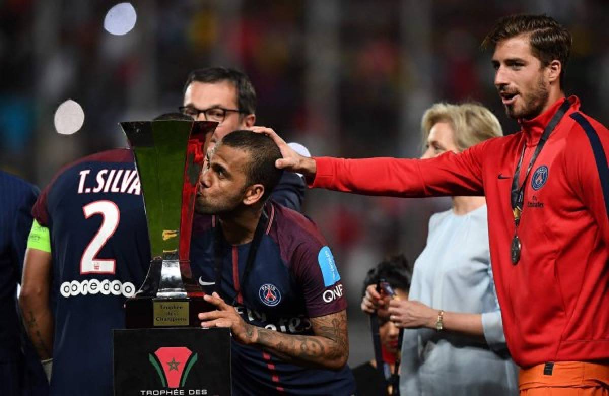 Paris Saint-Germain's Brazilian defender Dani Alves kisses the trophy as he celebrates with teammates after winning the French Trophy of Champions (Trophee des Champions) football match between Monaco (ASM) and Paris Saint-Germain (PSG) on July 29, 2017, at the Grand Stade in Tangiers. / AFP PHOTO / FRANCK FIFE