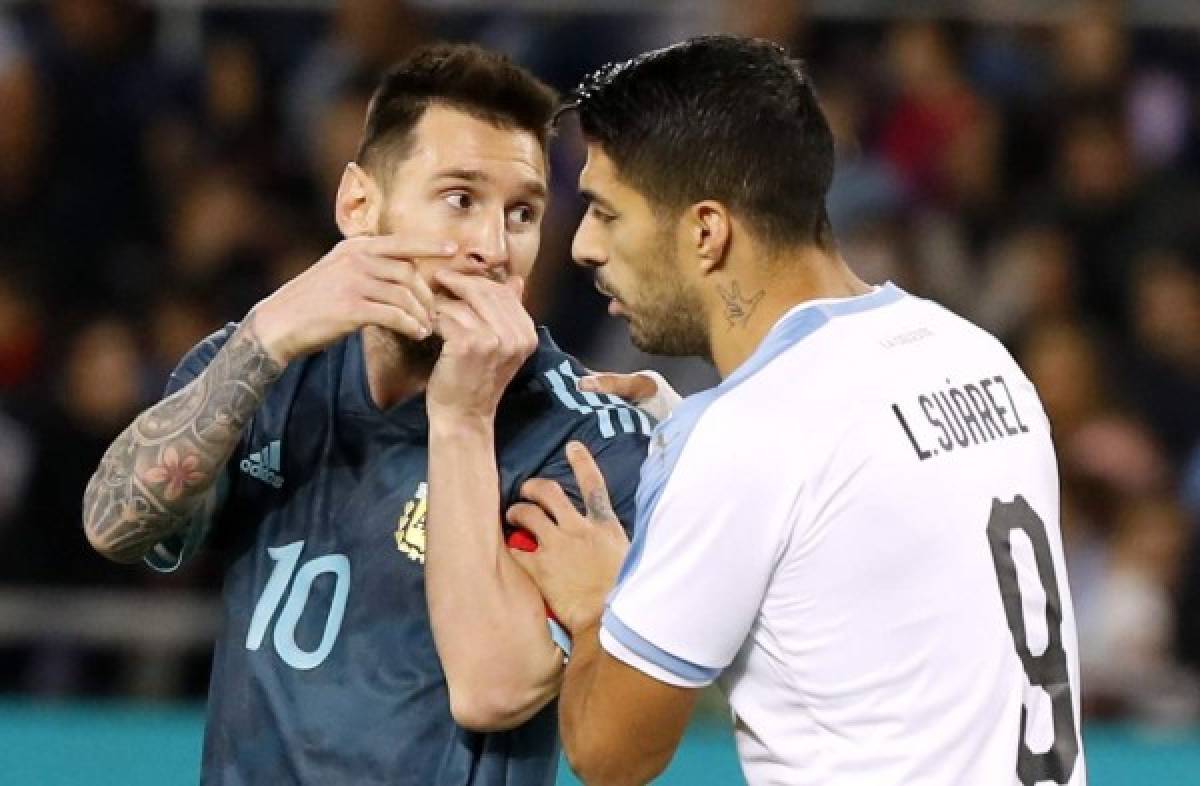 (FILES) In this file photo taken on November 18, 2019 Argentina's forward Lionel Messi talks with Uruguay's forward Luis Suarez during the friendly football match between Argentina and Uruguay at the Bloomfield stadium in the Israeli coastal city of Tel Aviv. - South America's football federations asked FIFA on March 11, 2020, to delay their qualifying matches for the 2022 World Cup in Qatar because of the global new coronavirus pandemic. 'The South American teams risk not being able to count on players they have picked and who play in Europe because they, arriving from countries with a high level of contagion, could be placed in quarantine,' said a letter from CONMEBOL, South American football's governing body, to FIFA Secretary General Fatma Samoura. (Photo by Jack GUEZ / AFP)