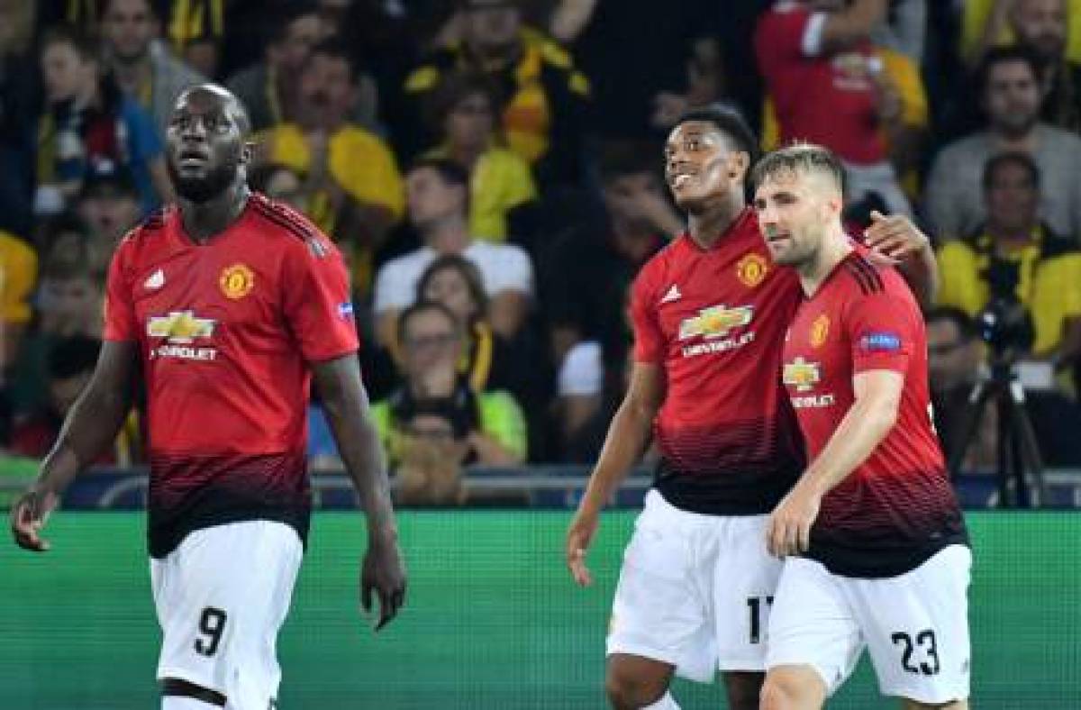 Manchester United's French striker Anthony Martial (C) celebrates after scoring with teammates Romelu Lukaku (L) and Luke Shaw (R) during the UEFA Champions League group H football match between Young Boys and Manchester United at The Stade de Suisse in Bern on September 19, 2018. / AFP PHOTO / Alain GROSCLAUDE