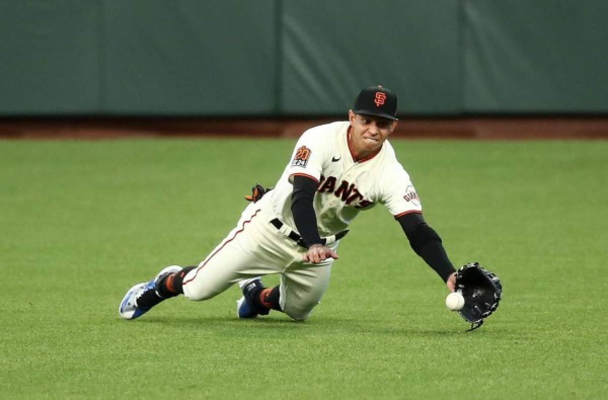 SAN FRANCISCO, CALIFORNIA - SEPTEMBER 16: Mauricio Dubon #1 of the San Francisco Giants tries unsuccessfully to catch a ball hit by Dylan Moore #25 of the Seattle Mariners in the first inning at Oracle Park on September 16, 2020 in San Francisco, California. Ezra Shaw/Getty Images/AFP== FOR NEWSPAPERS, INTERNET, TELCOS & TELEVISION USE ONLY ==