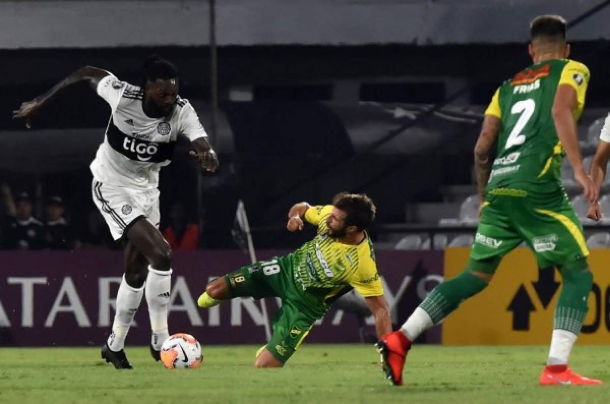 Argentina's Defensa y Justicia player Francisco Cerro (C) vies for the ball with Paraguay's Olimpia player Emmanuel Adebayor during their Copa Libertadores football match at Manuel Ferreira stadium, in Asuncion, on March 11, 2020. (Photo by NORBERTO DUARTE / AFP)