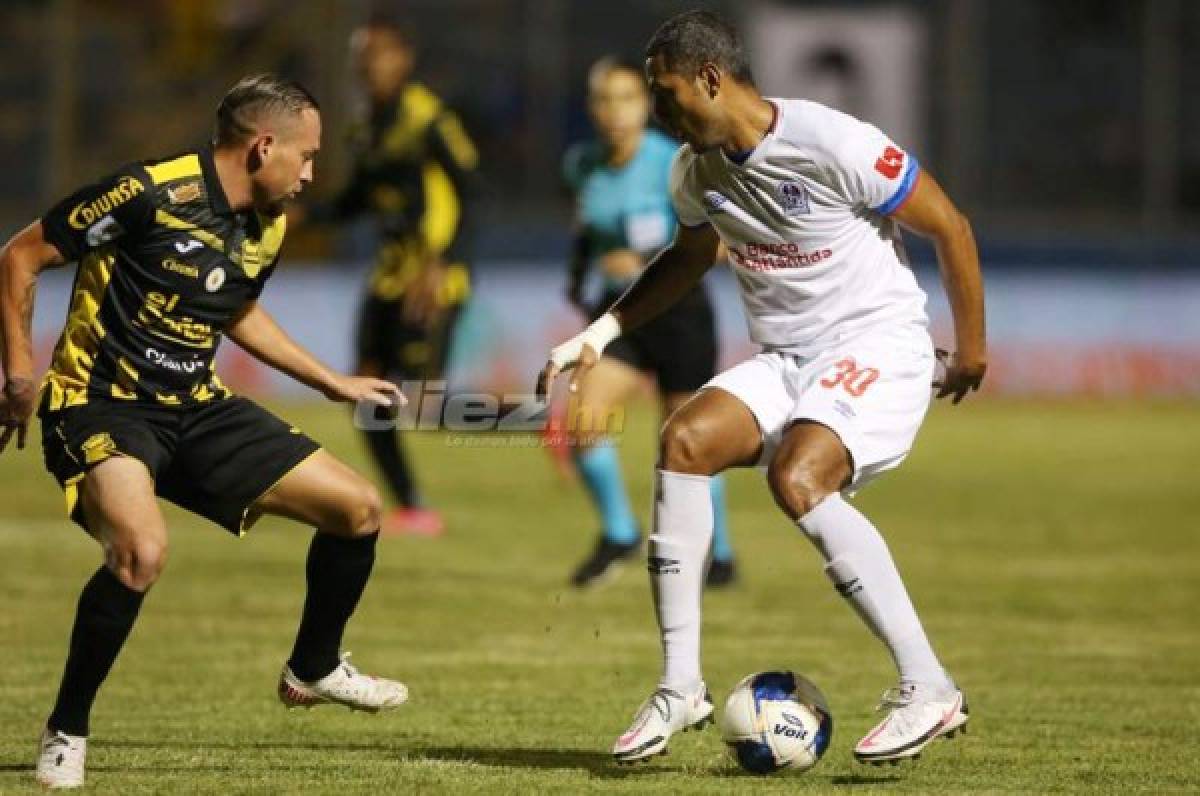 El delantero del Olimpia Eddie Hernández intenta quitarse la marca de Ilce Barahona del Real España. Foto DIEZ | Emilio Flores