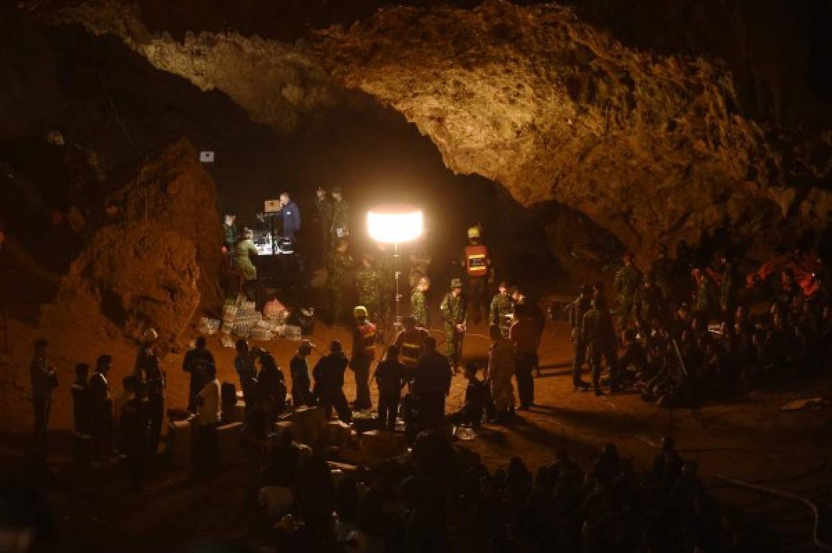 Thai soldiers relay electric cable deep into the Tham Luang cave at the Khun Nam Nang Non Forest Park in Chiang Rai on June 26, 2018 during a rescue operation for a missing children's football team and their coach. Desperate parents led a prayer ceremony outside a flooded cave in northern Thailand where 12 children and their football coach have been trapped for days, as military rescue divers packing food rations resumed their search on June 26. / AFP PHOTO / Lillian SUWANRUMPHA