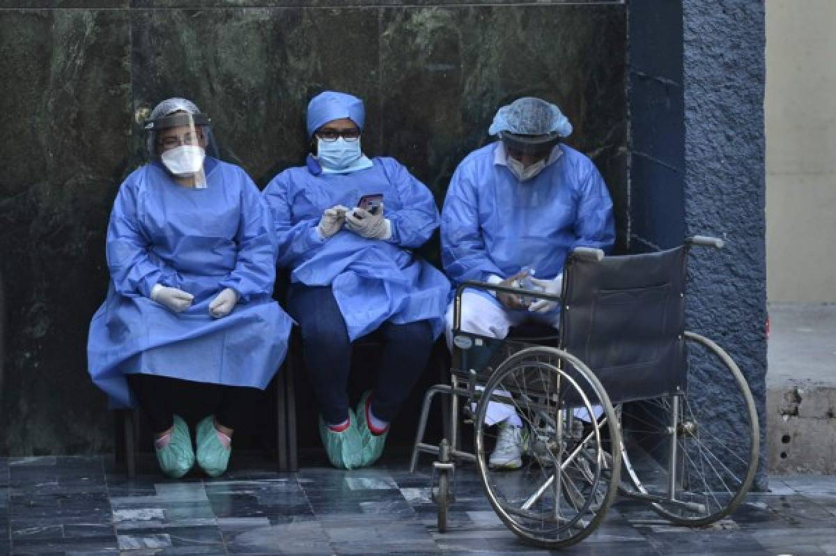 Health workers wear face masks and face shields against the spread of the new coronavirus at the Honduran Institute of Security in Tegucigalpa, where a patient died on March 31, 2020. - 141 cases of COVID-19 were registered so far in the Central American nation. (Photo by ORLANDO SIERRA / AFP)