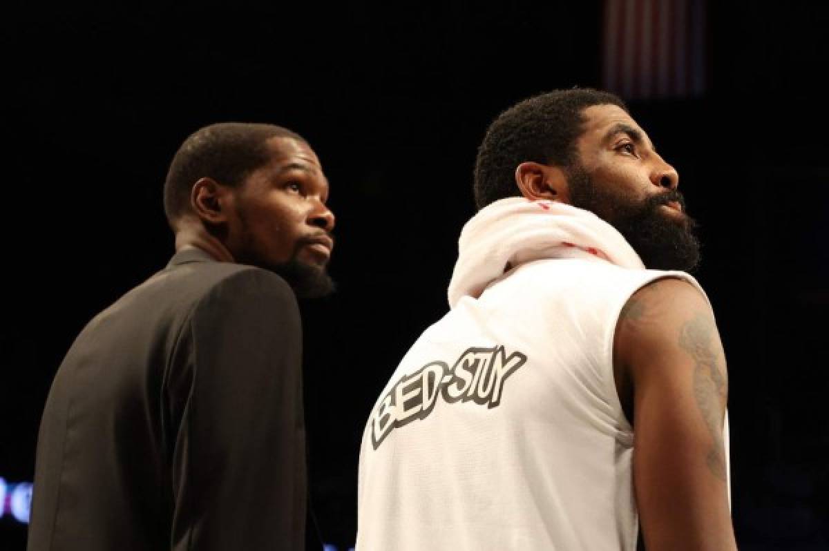 (FILES) In this file photo taken on January 18, 2020 Kevin Durant #7 and Kyrie Irving #11 of the Brooklyn Nets look on during their game against the Milwaukee Bucks at Barclays Center in New York City. NOTE TO USER: User expressly acknowledges and agrees that, by downloading and/or using this photograph, user is consenting to the terms and conditions of the Getty Images License Agreement. - Kevin Durant is reportedly among four Brooklyn Nets players who have tested positive for the new coronavirus and are in isolation.The injured Durant, who has yet to play for the Nets since signing for the club last year, confirmed to The Athletic website he had tested positive for the virus. (Photo by AL BELLO / GETTY IMAGES NORTH AMERICA / AFP)