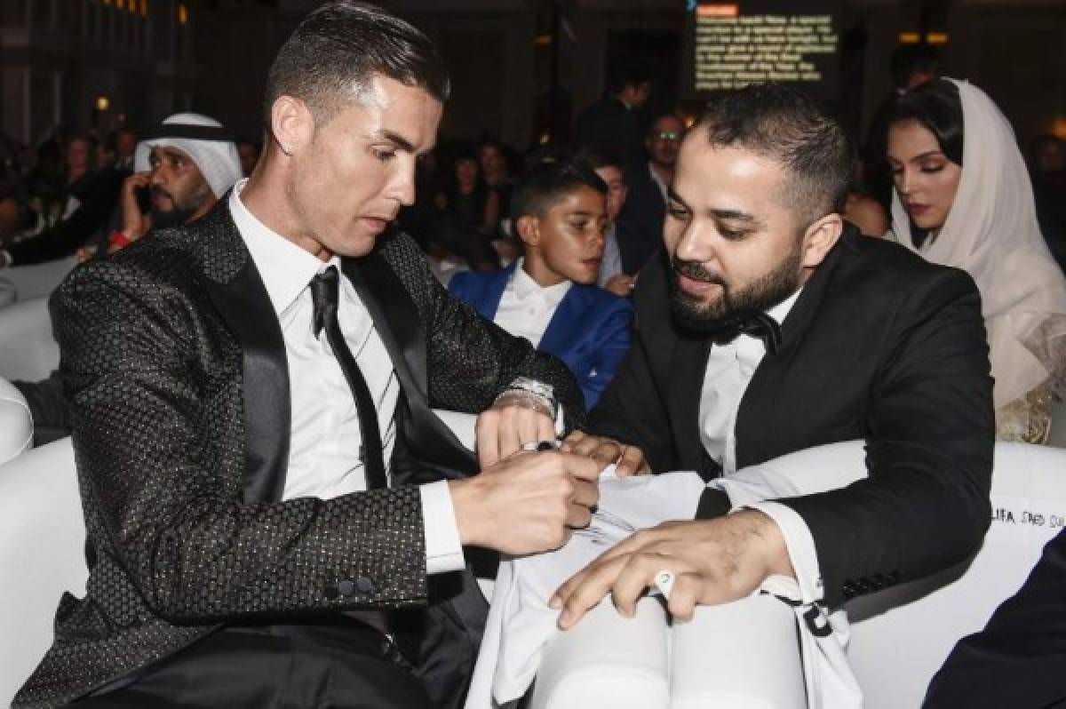Juventus' Portuguese forward Cristiano Ronaldo signs an autograph for a fan during the 10th edition of the Dubai Globe Soccer Awards on January 3, 2019 in Dubai. (Photo by Fabio FERRARI / La Presse / AFP) / Italy OUT - China OUT