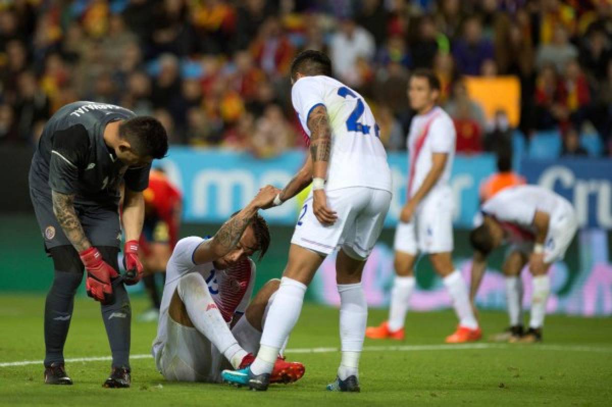 Costa Rica's defender Ronald Matarrita (R) helps Costa Rica's midfielder David Guzman during the international friendly football match Spain against Costa Rica at La Rosaleda stadium in Malaga on November 11, 2017. / AFP PHOTO / JORGE GUERRERO