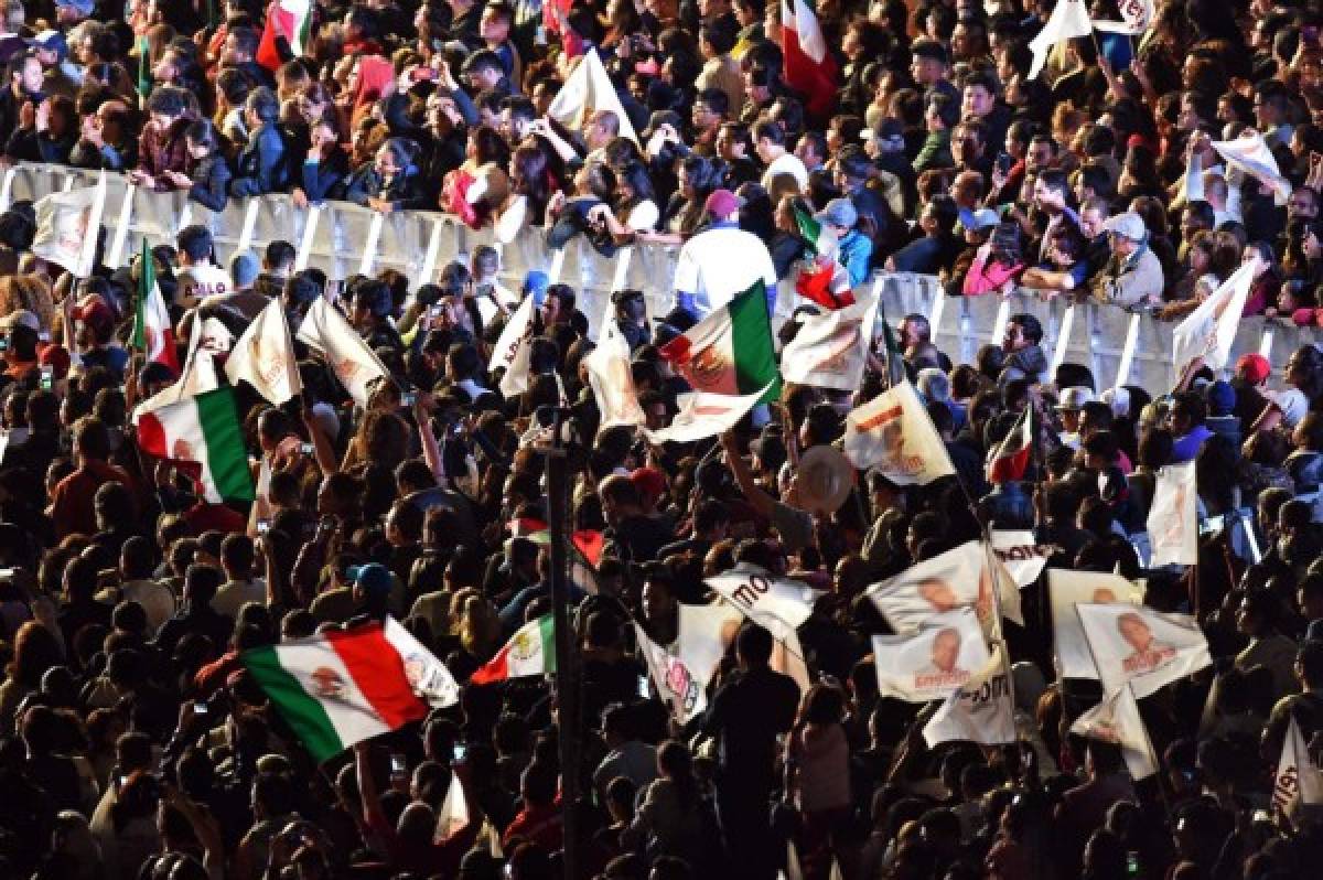 Supporters of the presidential candidate for the 'Juntos haremos historia' coalition, Andres Manuel Lopez Obrador, celebrate at the Zocalo square in Mexico City, after getting the preliminary results of the general elections on July 1, 2018. Anti-establishment leftist Andres Manuel Lopez Obrador won Mexico's presidential election Sunday by a large margin, according to exit polls, in a landmark break with the parties that have governed for nearly a century. / AFP PHOTO / RODRIGO ARANGUA