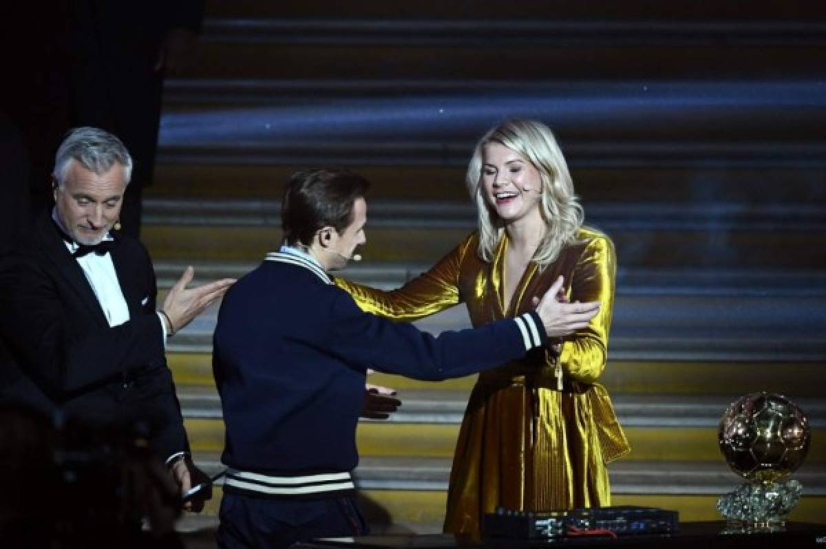 French DJ and producer Martin Solveig (C) invites Olympique Lyonnais' Norwegian forward Ada Hegerberg (R) to dance past Former French footballer and host David Ginola after receiving the 2018 FIFA Women's Ballon d'Or award for best player of the year during the 2018 FIFA Ballon d'Or award ceremony at the Grand Palais in Paris on December 3, 2018. - The winner of the 2018 Ballon d'Or will be revealed at a glittering ceremony in Paris on December 3 evening, with Croatia's Luka Modric and a host of French World Cup winners all hoping to finally end the 10-year duopoly of Cristiano Ronaldo and Lionel Messi. (Photo by FRANCK FIFE / AFP)