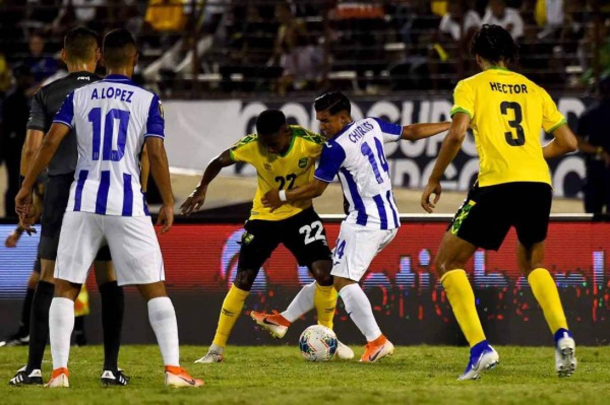 Jamaica's Devon Williams (#22) and Honduras's Michaell Chirinos (#14) fights for the ball during the 2019 Concacaf Gold Cup match between Jamaica and Honduras, on June 17, 2019 at Independence Park in Kingston. (Photo by CHANDAN KHANNA / AFP)