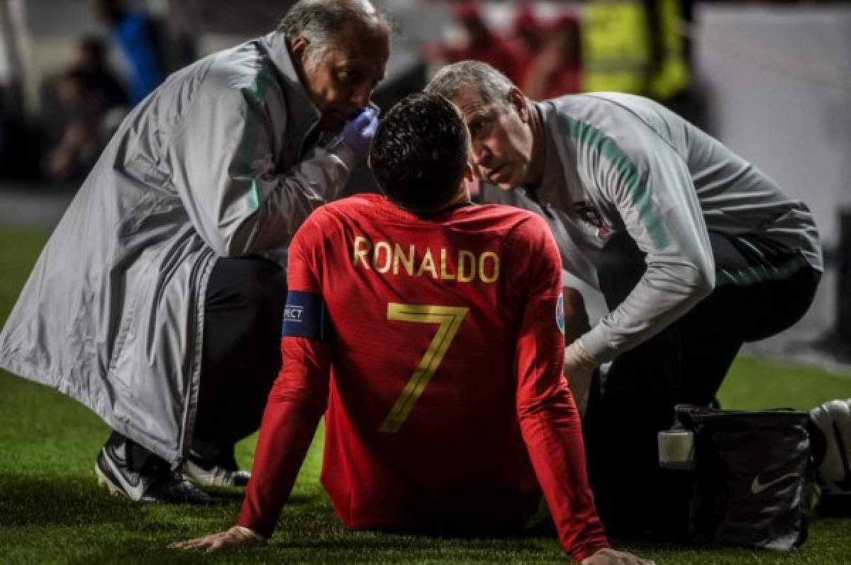 Doctors check on Portugal's forward Cristiano Ronaldo during the Euro 2020 qualifying group B football match between Portugal and Serbia at the Luz stadium in Lisbon on March 25, 2019. (Photo by PATRICIA DE MELO MOREIRA / AFP)