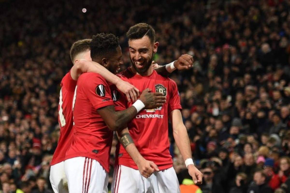 Manchester United's Portuguese midfielder Bruno Fernandes (R) celebrates scoring his team's first goalduring the UEFA Europa League round of 32 second leg football match between Manchester United and Club Brugge at Old Trafford in Manchester, north west England, on February 27, 2020. (Photo by Oli SCARFF / AFP)