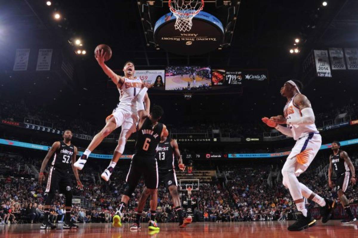 PHOENIX, AZ - MARCH 27: Devin Booker #1 of the Phoenix Suns shoots the ball against the Washington Wizards on March 27, 2019 at Talking Stick Resort Arena in Phoenix, Arizona. NOTE TO USER: User expressly acknowledges and agrees that, by downloading and or using this photograph, user is consenting to the terms and conditions of the Getty Images License Agreement. Mandatory Copyright Notice: Copyright 2019 NBAE Barry Gossage/NBAE via Getty Images/AFP