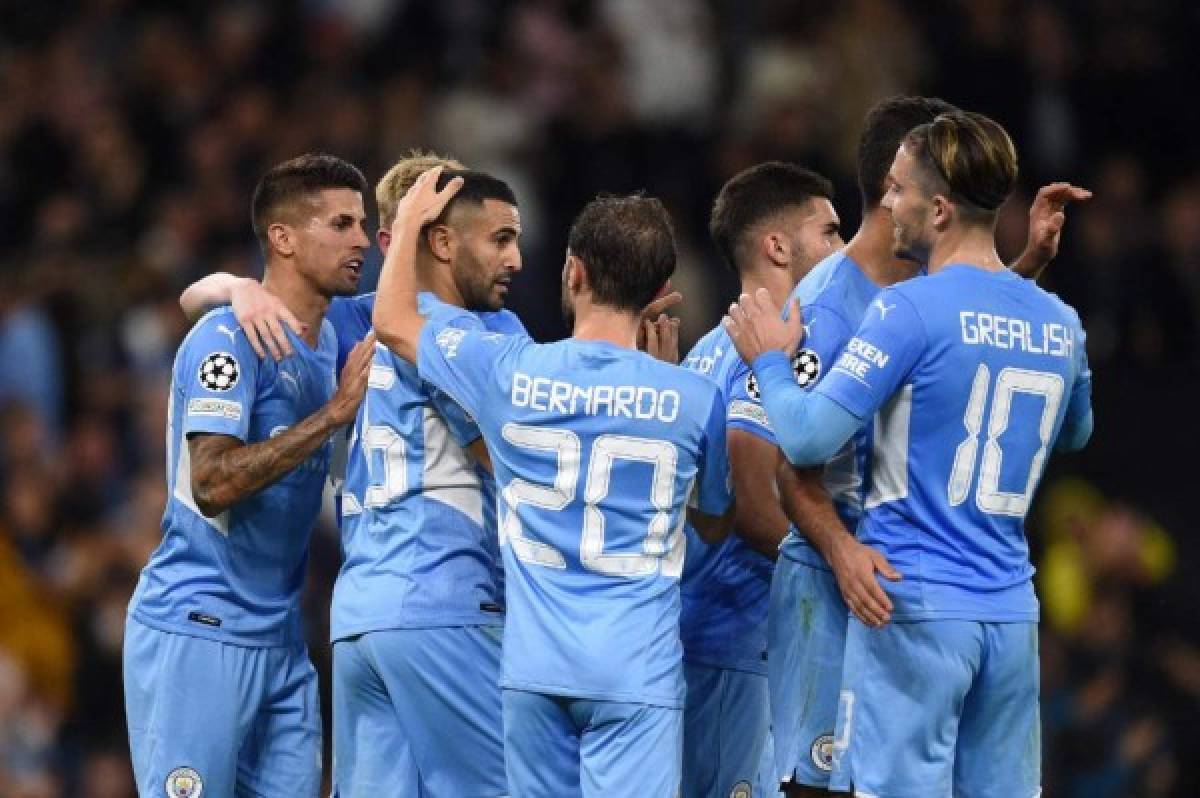 Manchester City's Algerian midfielder Riyad Mahrez (2nd L) celebrates scoring his teams third goal from the penalty spot during the UEFA Champions League 1st round Group A football match between Manchester City and RB Leipzig at the Etihad Stadium in Manchester, north west England, on September 15, 2021. (Photo by Oli SCARFF / AFP)