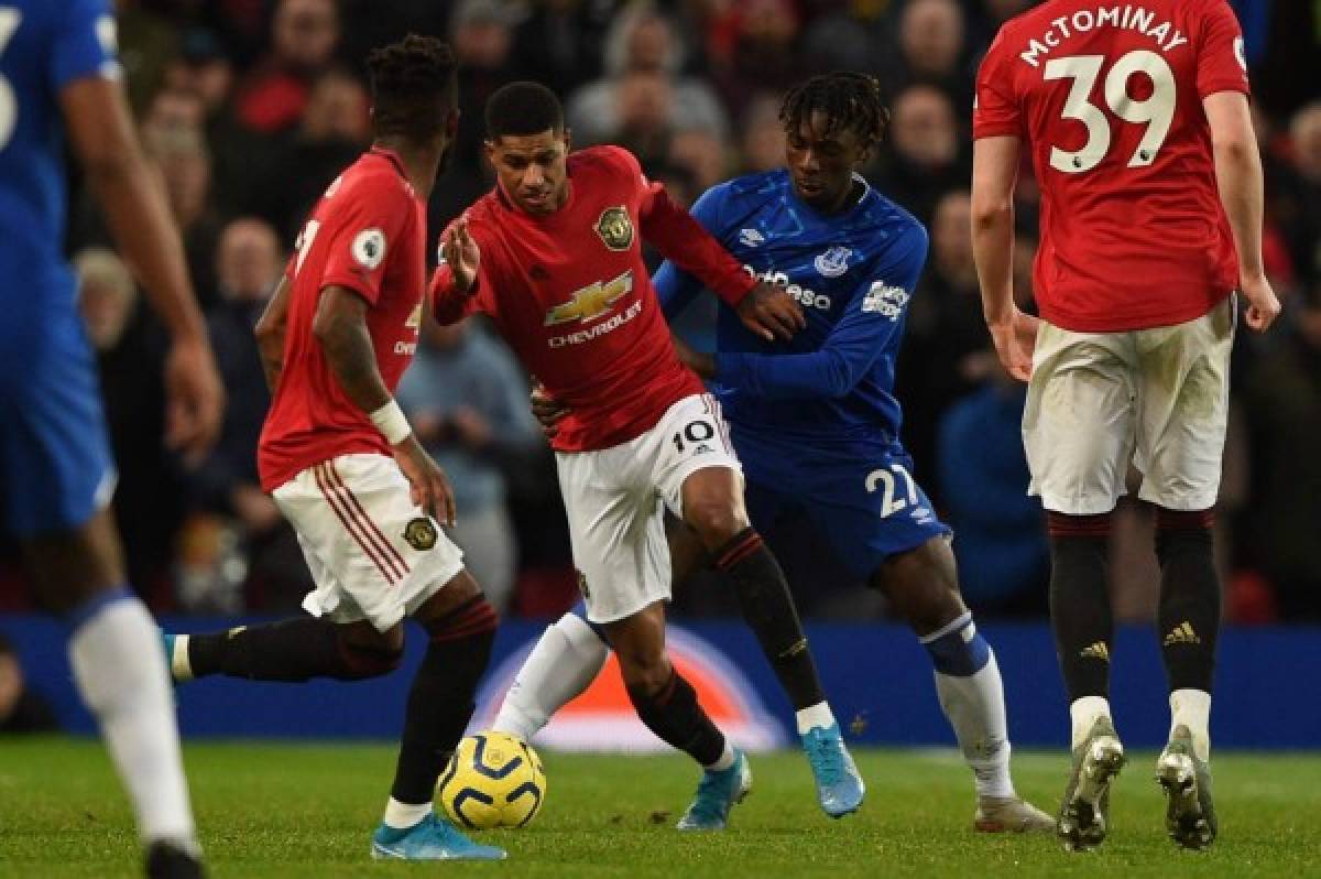 Manchester United's English striker Marcus Rashford (C) takes on Everton's Italian midfielder Moise Kean (R) during the English Premier League football match between Manchester United and Everton at Old Trafford in Manchester, north west England, on December 15, 2019. (Photo by Oli SCARFF / AFP) / RESTRICTED TO EDITORIAL USE. No use with unauthorized audio, video, data, fixture lists, club/league logos or 'live' services. Online in-match use limited to 120 images. An additional 40 images may be used in extra time. No video emulation. Social media in-match use limited to 120 images. An additional 40 images may be used in extra time. No use in betting publications, games or single club/league/player publications. /