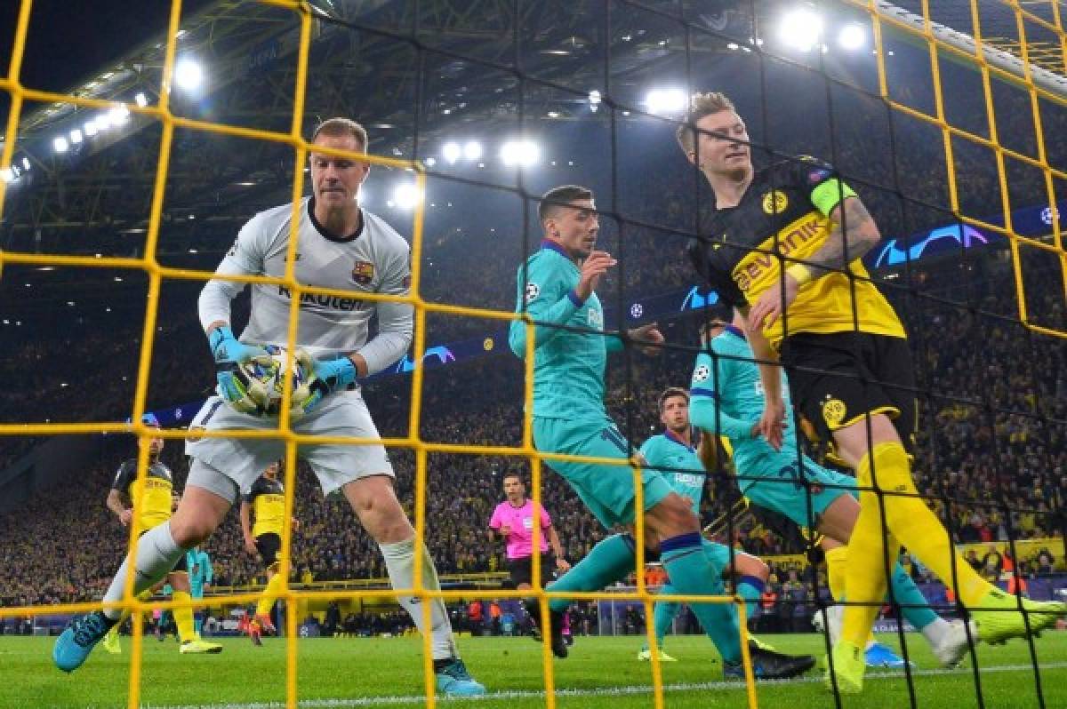 Barcelona's German goalkeeper Marc-Andre Ter Stegen (L) holds the ball after saving Dortmund's German forward Marco Reus' penaty during the UEFA Champions League Group F football match Borussia Dortmund v FC Barcelona in Dortmund, western Germany, on September 17, 2019. (Photo by John MACDOUGALL / AFP)