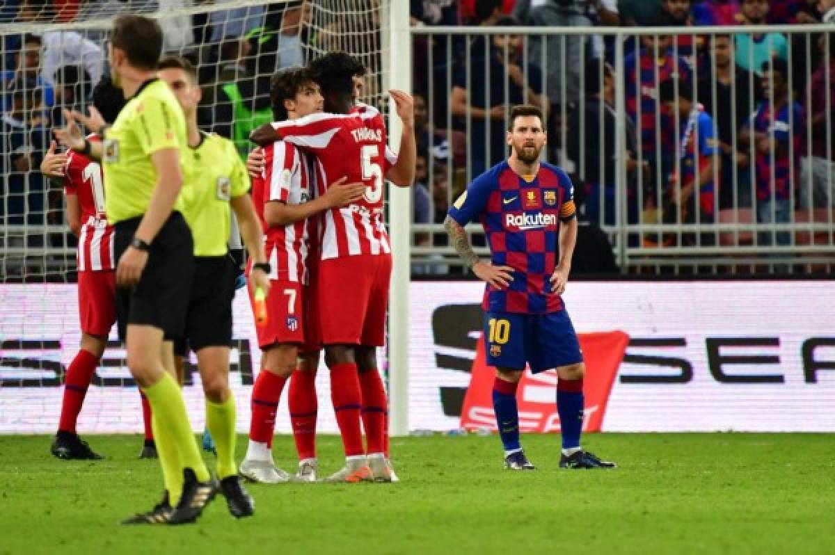 Barcelona's Argentine forward Lionel Messi (R) watches as Atletico's players celebrate their win during the Spanish Super Cup semi final between Barcelona and Atletico Madrid on January 9, 2020, at the King Abdullah Sport City in the Saudi Arabian port city of Jeddah. - The winner will face Real Madrid in the final on January 12. (Photo by Giuseppe CACACE / AFP)
