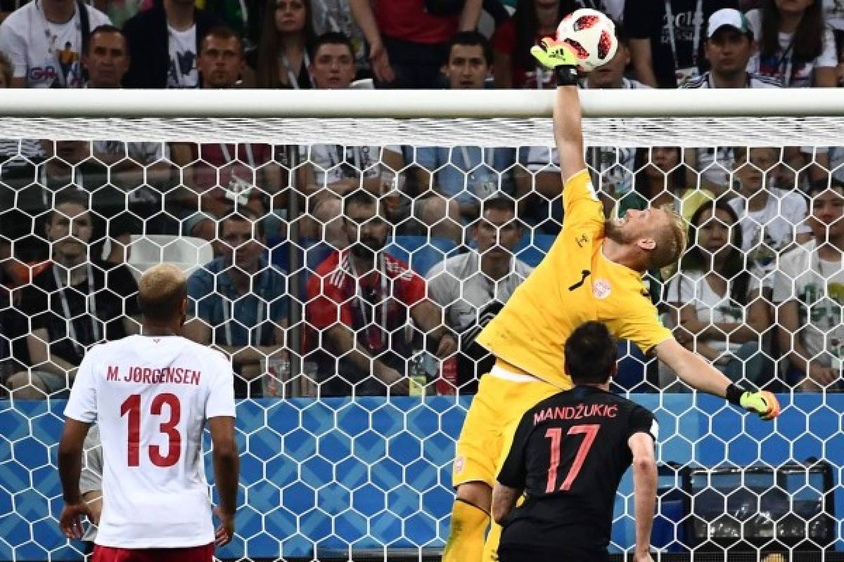 Denmark's goalkeeper Kasper Schmeichel (back) stops a shot on goal by Croatia's forward Mario Mandzukic during the Russia 2018 World Cup round of 16 football match between Croatia and Denmark at the Nizhny Novgorod Stadium in Nizhny Novgorod on July 1, 2018. / AFP PHOTO / Jewel SAMAD / RESTRICTED TO EDITORIAL USE - NO MOBILE PUSH ALERTS/DOWNLOADS