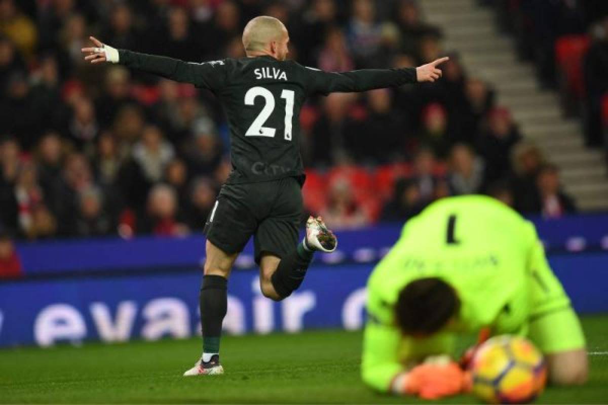 Stoke City's English goalkeeper Jack Butland (R) reacts as Manchester City's Spanish midfielder David Silva celebrates after scoring the opening goal of the English Premier League football match between Stoke City and Manchester City at the Bet365 Stadium in Stoke-on-Trent, central England on March 12, 2018. / AFP PHOTO / Paul ELLIS / RESTRICTED TO EDITORIAL USE. No use with unauthorized audio, video, data, fixture lists, club/league logos or 'live' services. Online in-match use limited to 75 images, no video emulation. No use in betting, games or single club/league/player publications. /