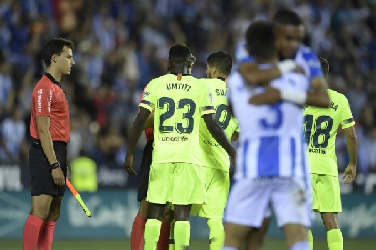 Leganes players celebrate their win as Barcelona players protest to the referee at the end of the Spanish league football match Club Deportivo Leganes SAD against FC Barcelona at the Estadio Municipal Butarque in Leganes on the outskirts of Madrid on September 26, 2018. / AFP PHOTO / OSCAR DEL POZO