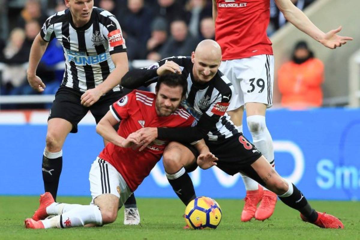Newcastle United's English midfielder Jonjo Shelvey (R) tangles with Manchester United's Spanish midfielder Juan Mata (L) during the English Premier League football match between Newcastle United and Manchester United at St James' Park in Newcastle-upon-Tyne, north east England on February 11, 2018. / AFP PHOTO / Lindsey PARNABY / RESTRICTED TO EDITORIAL USE. No use with unauthorized audio, video, data, fixture lists, club/league logos or 'live' services. Online in-match use limited to 75 images, no video emulation. No use in betting, games or single club/league/player publications. /