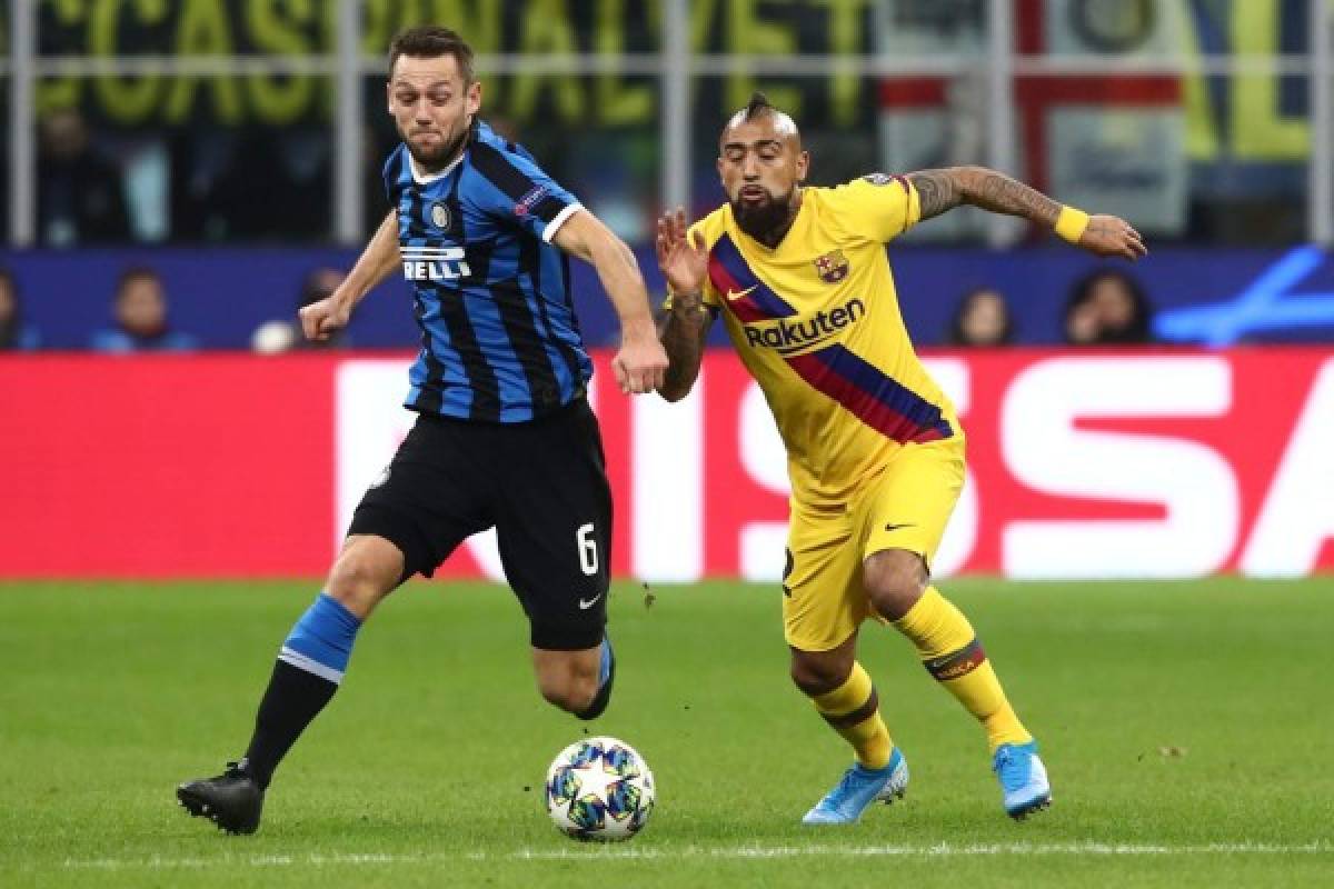 Inter Milan's Dutch defender Stefan de Vrij (L) and Barcelona's Chilean midfielder Arturo Vidal go for the ball during the UEFA Champions League Group F football match Inter Milan vs Barcelona on December 10, 2019 at the San Siro stadium in Milan. (Photo by Isabella BONOTTO / AFP)