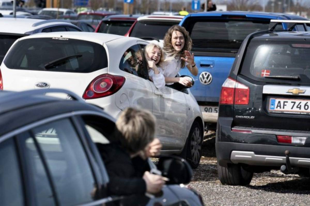 Young people react during the drive-in Eastern service at the parking lot at Aalborg Airport on April 12, 2020 amid the spread of the novel coronavirus COVID-19. (Photo by Henning Bagger / Ritzau Scanpix / AFP) / Denmark OUT