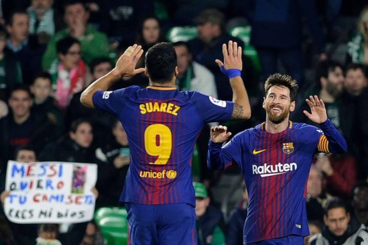 Barcelona's Argentinian forward Lionel Messi (R) celebrates with Barcelona's Uruguayan forward Luis Suarez after scoring a goal during the Spanish league football match between Real Betis and FC Barcelona at the Benito Villamarin stadium in Sevilla on January 21, 2018. / AFP PHOTO / CRISTINA QUICLER
