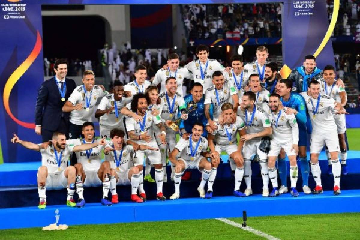 Real Madrid's players celebrate with the trophy after winning the FIFA Club World Cup final football match Spain's Real Madrid vs Abu Dhabi's Al Ain at the Zayed Sports City Stadium in Abu Dhabi, the capital of the United Arab Emirates, on December 22, 2018. (Photo by Giuseppe CACACE / AFP)