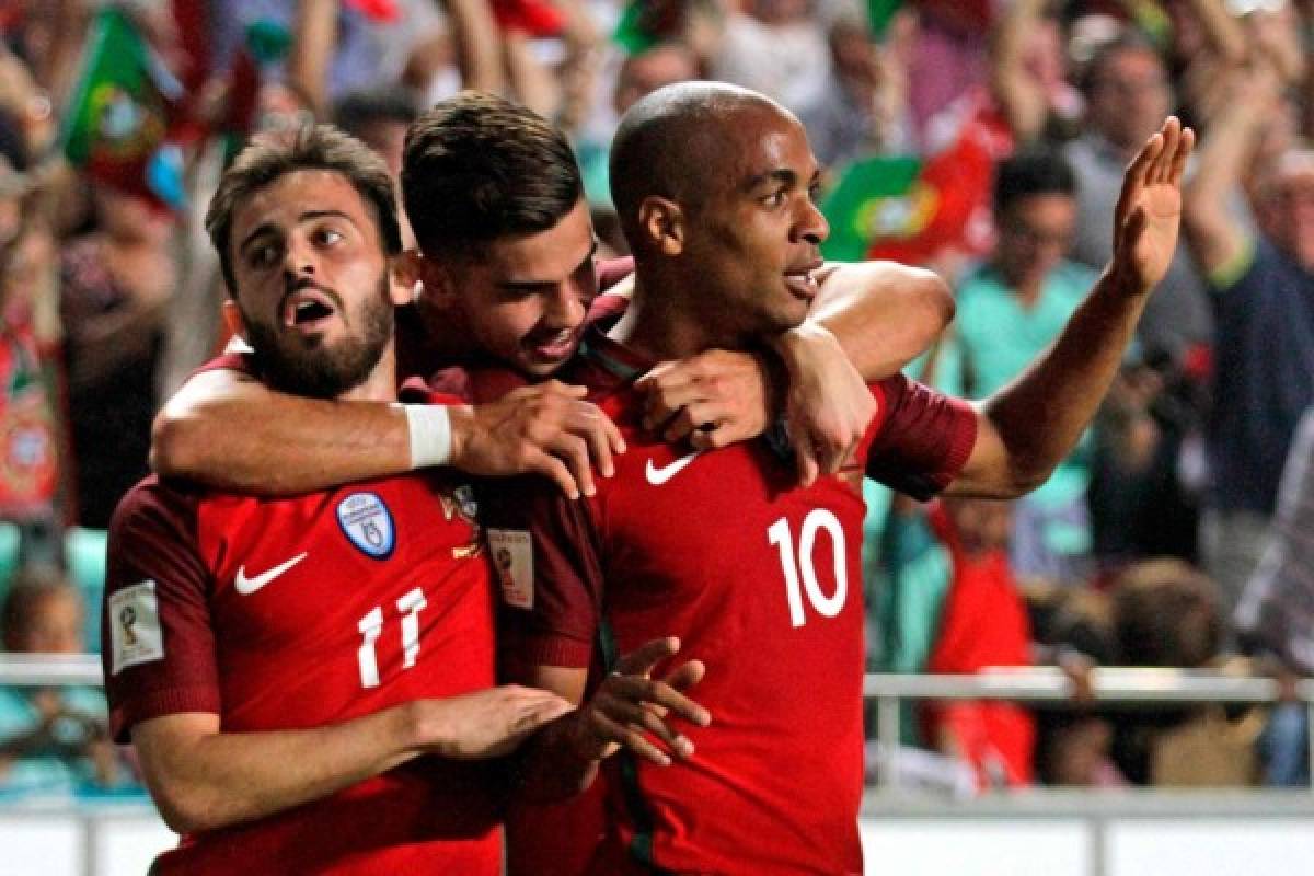 Portugals midfielder Joao Mario celebrates forward Andre Silva (C) and midfielder Bernardo Silva after Switzerland's defender Johan Djourou scored an own goal during the FIFA World Cup 2018 Group B qualifier football match between Portugal and Switzerland at the Luz Stadium in Lisbon on October 10, 2017. / AFP PHOTO / JOSE MANUEL RIBEIRO