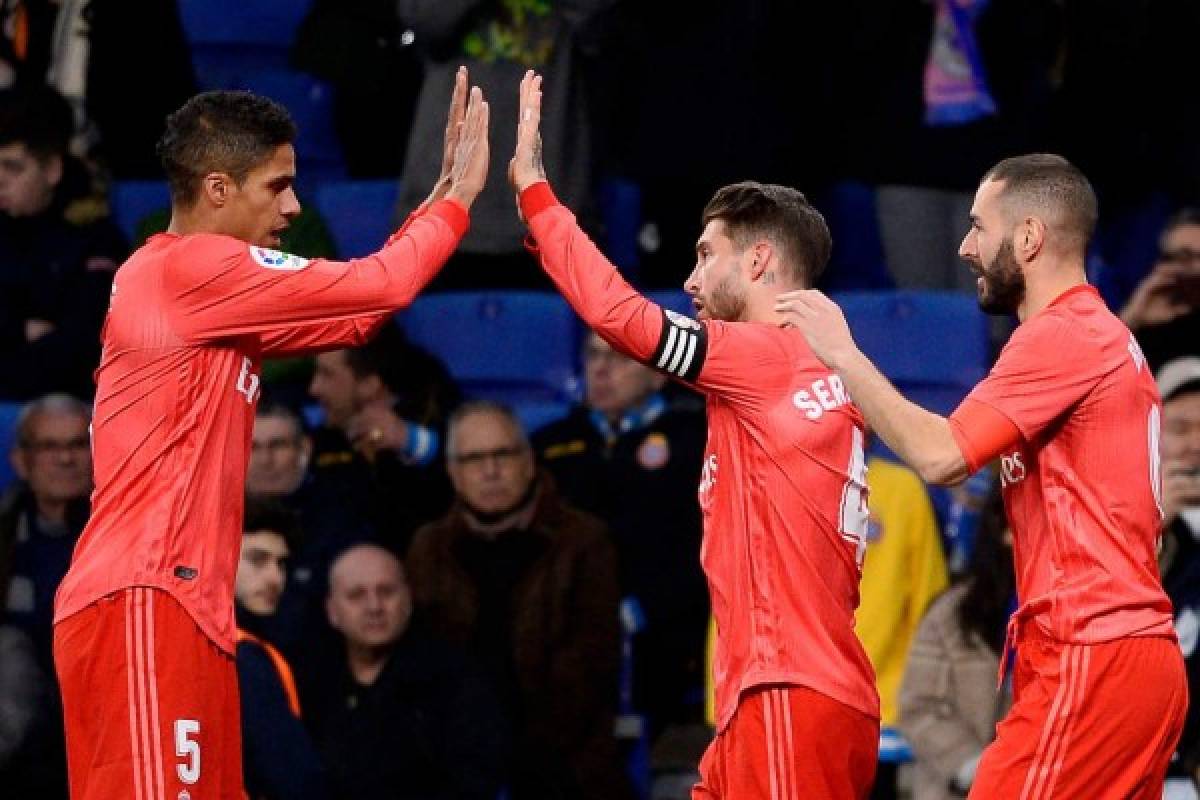 Real Madrid's French forward Karim Benzema (R) celebrates with Real Madrid's French defender Raphael Varane (L) and Real Madrid's Spanish defender Sergio Ramos after scoring a goal during the Spanish league football match between RCD Espanyol and Real Madrid CF at the RCDE Stadium in Cornella de Llobregat on January 27, 2019. (Photo by Josep LAGO / AFP)