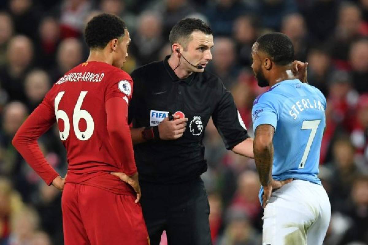 English referee Michael Oliver (C) chats with Manchester City's English midfielder Raheem Sterling (R) and Liverpool's English defender Trent Alexander-Arnold (L) during the English Premier League football match between Liverpool and Manchester City at Anfield in Liverpool, north west England on November 10, 2019. (Photo by Paul ELLIS / AFP) / RESTRICTED TO EDITORIAL USE. No use with unauthorized audio, video, data, fixture lists, club/league logos or 'live' services. Online in-match use limited to 120 images. An additional 40 images may be used in extra time. No video emulation. Social media in-match use limited to 120 images. An additional 40 images may be used in extra time. No use in betting publications, games or single club/league/player publications. /
