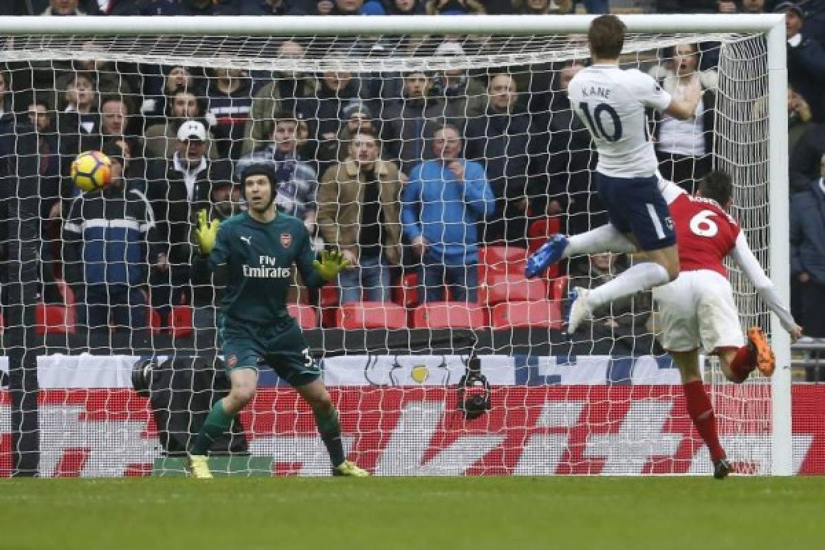 Tottenham Hotspur's English striker Harry Kane (2R) scores the opening goal past Arsenal's Czech goalkeeper Petr Cech (L) during the English Premier League football match between Tottenham Hotspur and Arsenal at Wembley Stadium in London, on February 10, 2018. / AFP PHOTO / IKIMAGES / Ian KINGTON / RESTRICTED TO EDITORIAL USE. No use with unauthorized audio, video, data, fixture lists, club/league logos or 'live' services. Online in-match use limited to 45 images, no video emulation. No use in betting, games or single club/league/player publications. /