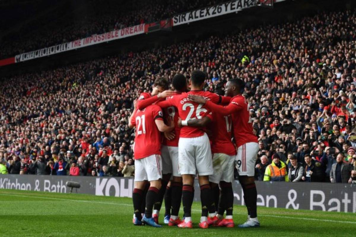 Manchester United players celebrate the opening goal scored by Manchester United's Portuguese midfielder Bruno Fernandes during the English Premier League football match between Manchester United and Watford at Old Trafford in Manchester, north west England, on February 23, 2020. (Photo by Paul ELLIS / AFP) / RESTRICTED TO EDITORIAL USE. No use with unauthorized audio, video, data, fixture lists, club/league logos or 'live' services. Online in-match use limited to 120 images. An additional 40 images may be used in extra time. No video emulation. Social media in-match use limited to 120 images. An additional 40 images may be used in extra time. No use in betting publications, games or single club/league/player publications. /