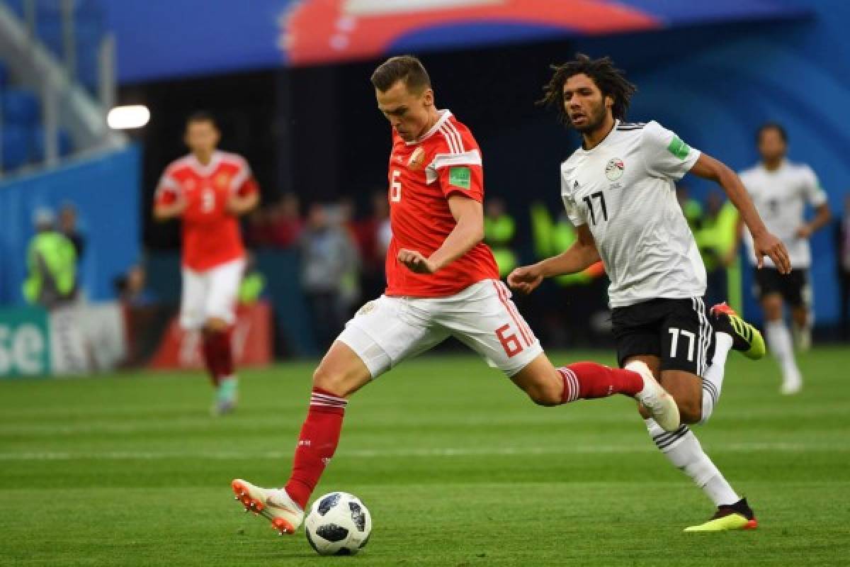 Russia's midfielder Denis Cheryshev (L) and Egypt's midfielder Mohamed Elneny vie during the Russia 2018 World Cup Group A football match between Russia and Egypt at the Saint Petersburg Stadium in Saint Petersburg on June 19, 2018. / AFP PHOTO / Paul ELLIS / RESTRICTED TO EDITORIAL USE - NO MOBILE PUSH ALERTS/DOWNLOADS