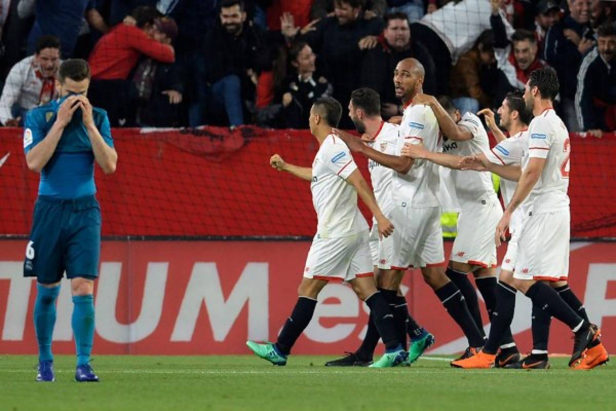 Real Madrid's Spanish defender Nacho Fernandez (L) reacts as Sevilla's players celebrate after scoring a goal during the Spanish league football match between Sevilla and Real Madrid at the Ramon Sanchez Pizjuan stadium in Sevilla on May 9, 2018. / AFP PHOTO / CRISTINA QUICLER
