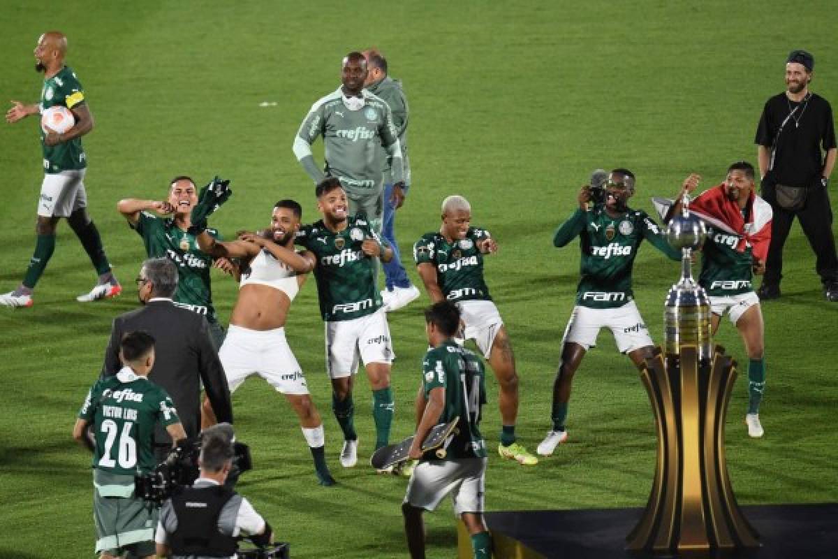 Palmeiras players celebrate after defeating Flamengo in the Copa Libertadores football tournament all-Brazilian final match, at the Centenario stadium in Montevideo, on November 27, 2021. (Photo by EITAN ABRAMOVICH / AFP)