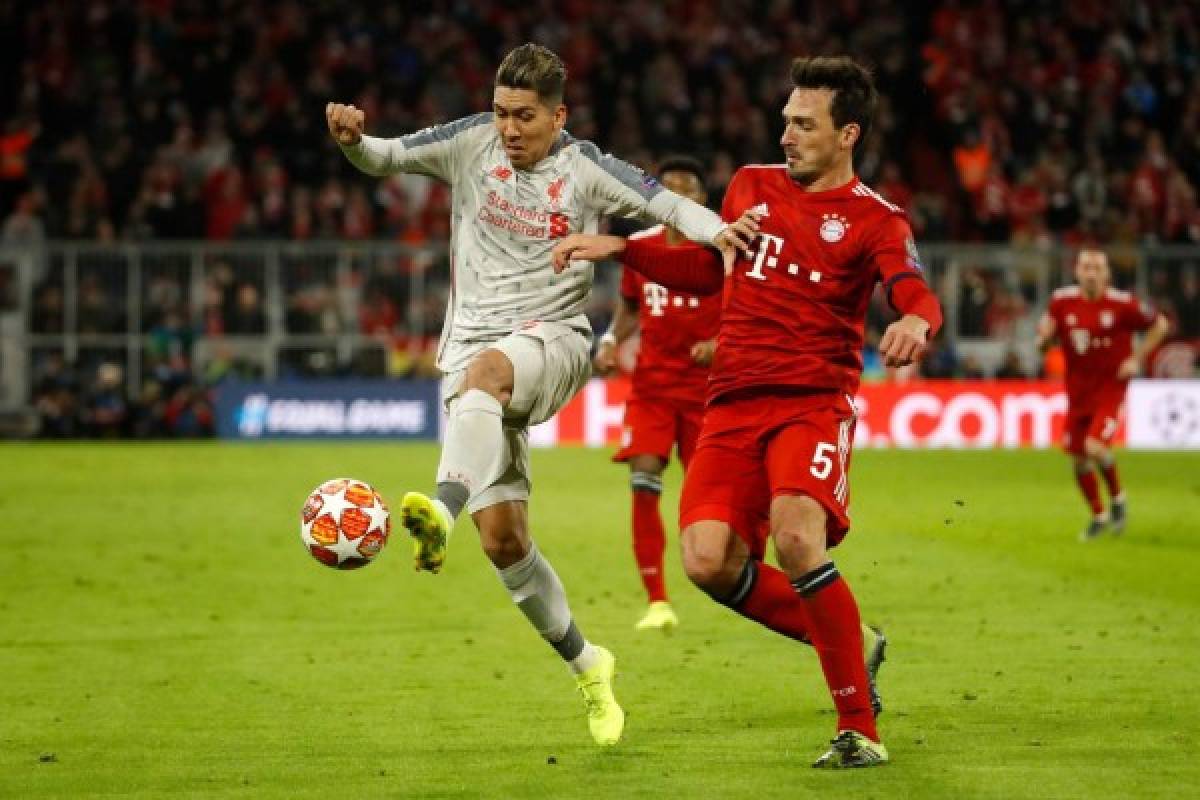 Liverpool's Brazilian forward Roberto Firmino (L) and Bayern Munich's German defender Mats Hummels vie for the ball during the UEFA Champions League, last 16, second leg football match Bayern Munich v Liverpool in Munich, southern Germany, on March 13, 2019. (Photo by Odd ANDERSEN / AFP)
