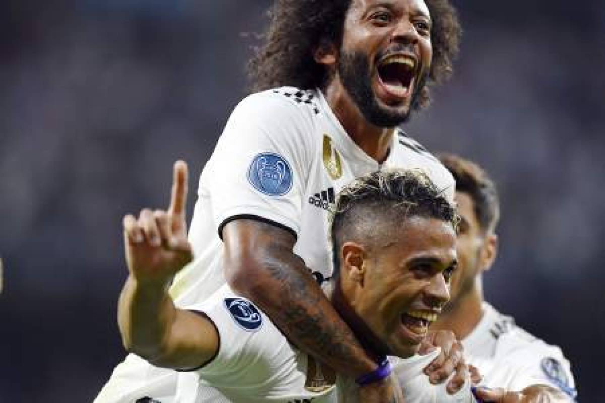 Real Madrid's Spanish-Dominican forward Mariano (bottom) celebrates his goal with Real Madrid's Brazilian defender Marcelo during the UEFA Champions League group G football match between Real Madrid CF and AS Roma at the Santiago Bernabeu stadium in Madrid on September 19, 2018. / AFP PHOTO / GABRIEL BOUYS