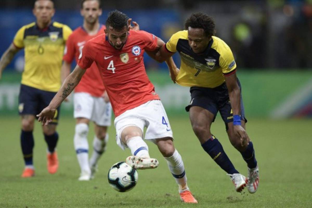 Chile's Maurico Isla (L) and Ecuador's Romario Ibarra vie for the ball during their Copa America football tournament group match at the Fonte Nova Arena in Salvador, Brazil, on June 21, 2019. (Photo by Juan MABROMATA / AFP)