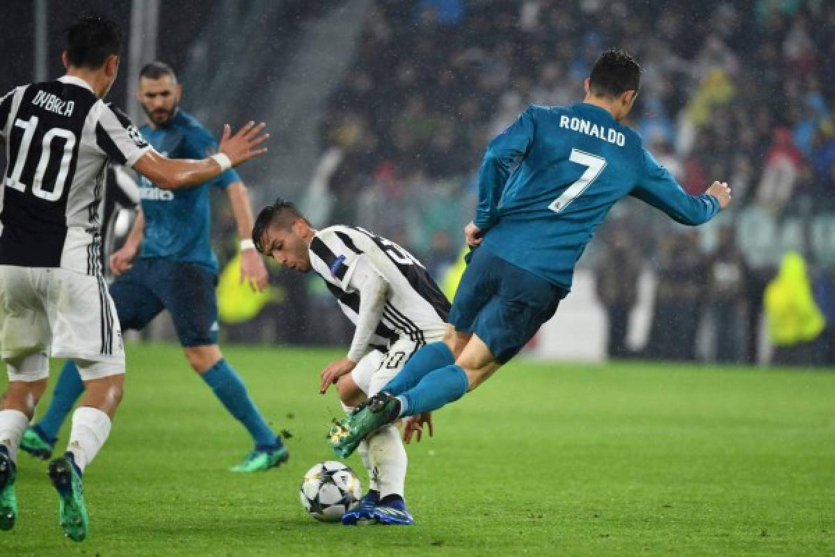 Real Madrid's Portuguese forward Cristiano Ronaldo (R) is tackled by Juventus' midfielder from Uruguay Rodrigo Bentancur during the UEFA Champions League quarter-final first leg football match between Juventus and Real Madrid at the Allianz Stadium in Turin on April 3, 2018. / AFP PHOTO / Alberto PIZZOLI